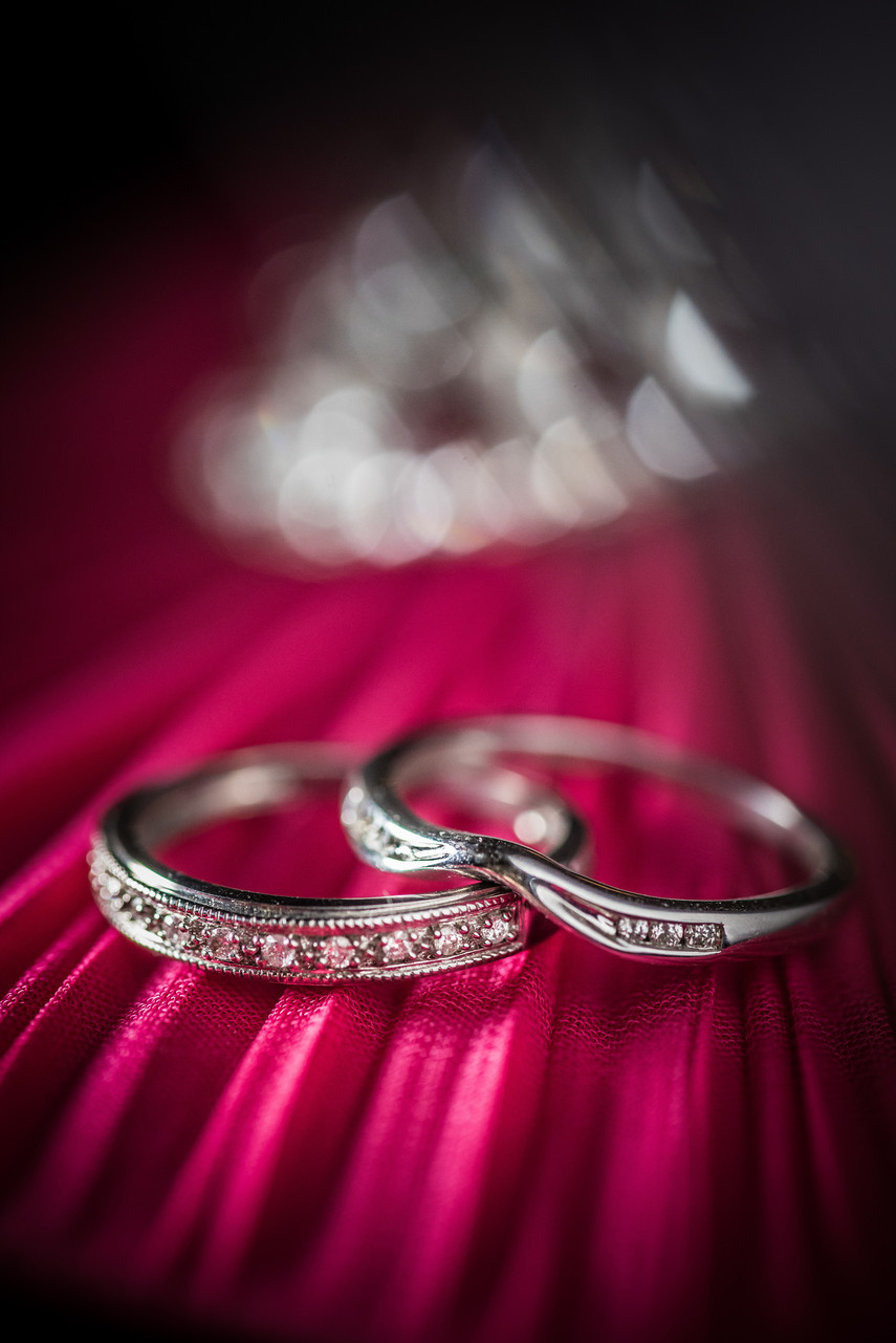 Wedding rings photographed on a red background.