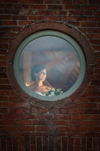 Bride photographed in window at Shustoke Barn.