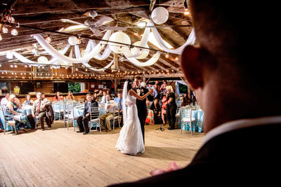 A groomsman looks on as the bride and groom first dance