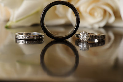 Wedding Ring Reflections with white roses behind.