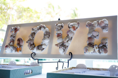 Seashell designed wedding detail sign that says LOVE