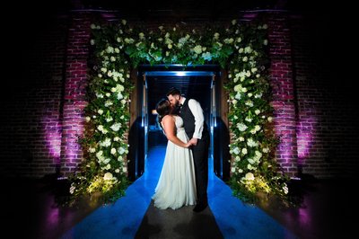 Bride and Groom Under Floral Archway at Press Room