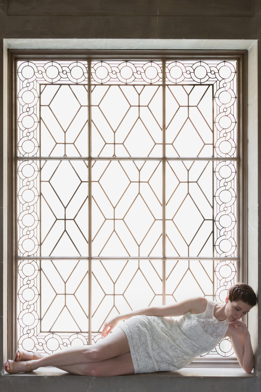 Bride reclines in art deco window