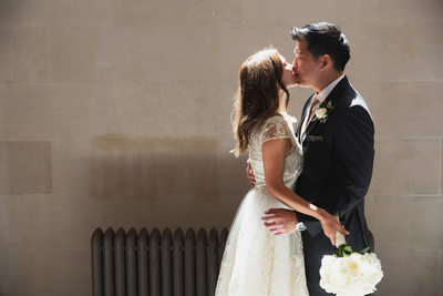 Bride and groom kiss at City Hall