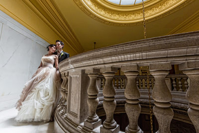 Bride and groom pose on fourth floor landing