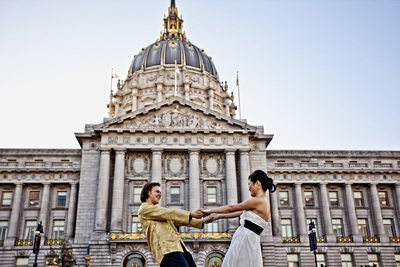 Playful bride and groom outside city hall