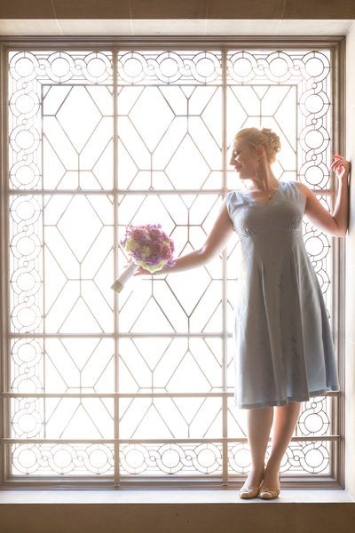 Bride with flowers in big window
