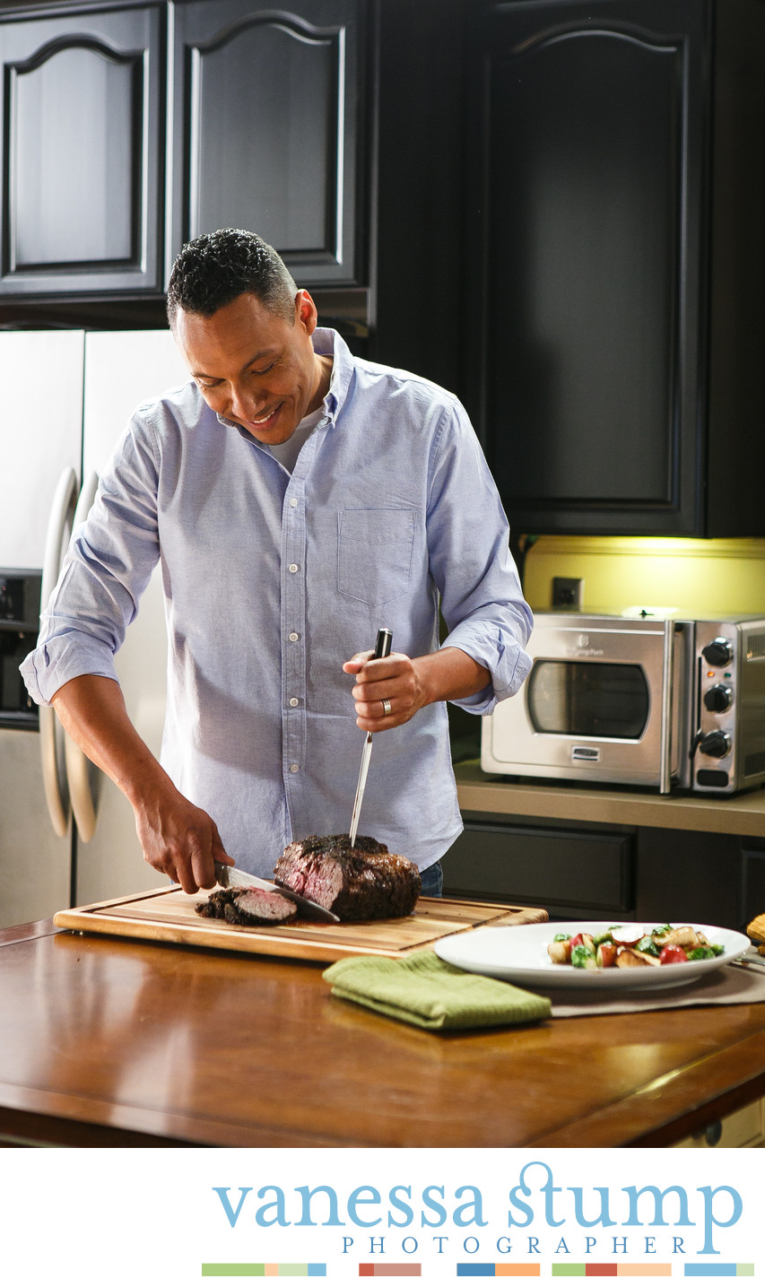 Man in kitchen cutting a beef roast