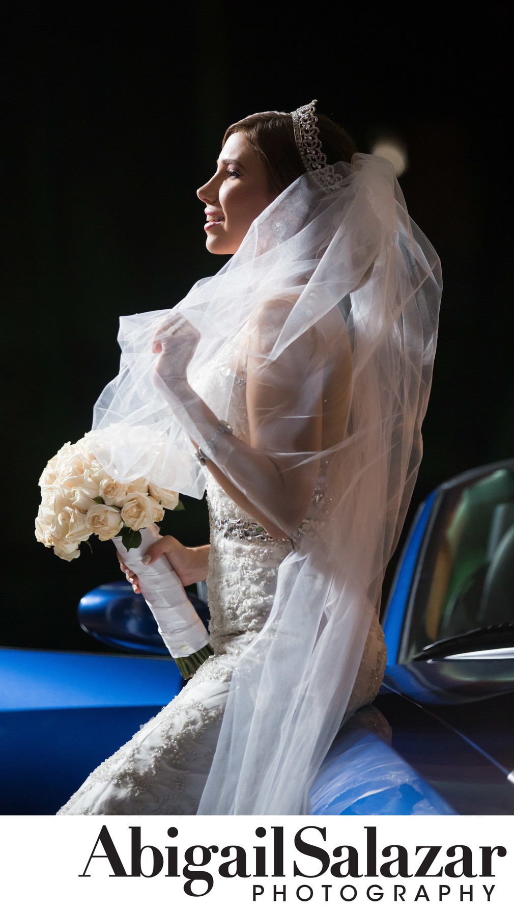 Sophisticated bride and blue wedding car