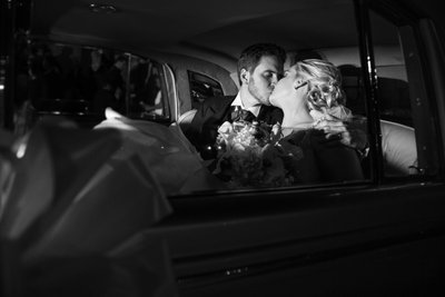 Lovely bride and groom kissing inside the wedding car