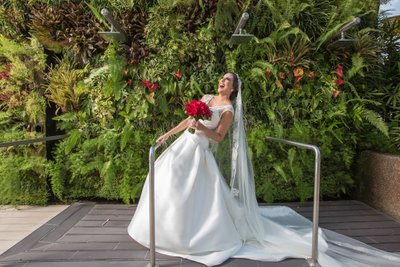 Bride laughing & posing with her red wedding bouquet