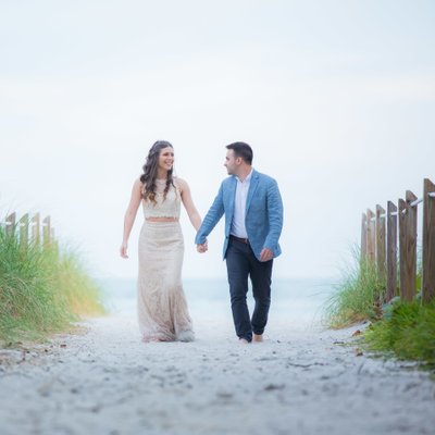 Adorable bride and groom walking on the beach