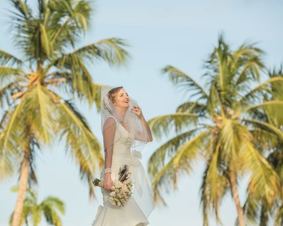 A happy bride on a back ground of palm trees