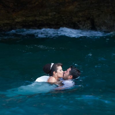 Unique wedding photography: Bride and groom kiss in the ocean