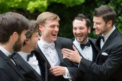 Groomsmen Laughing With Groom On Wedding Day Outdoors