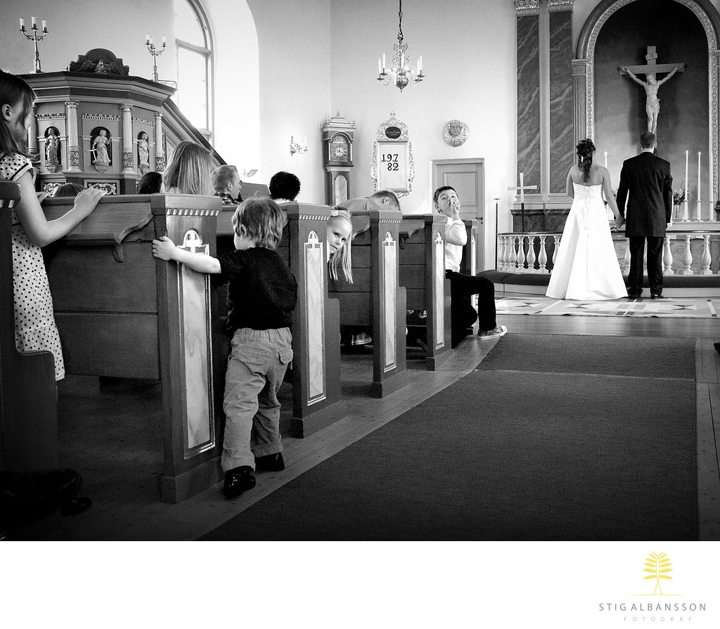 Barn leker och hyschar under vigsel i Starrkärr kyrka