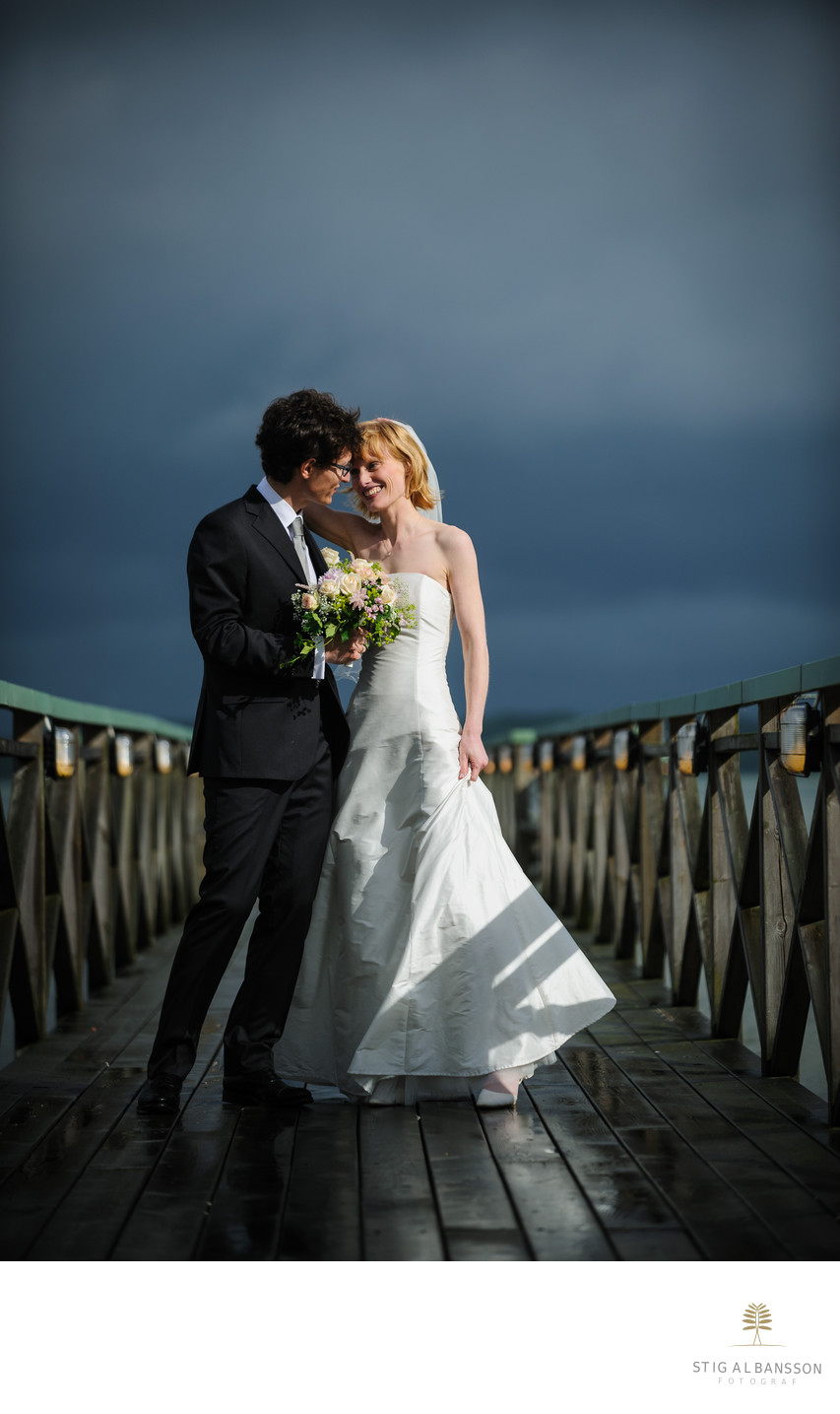 Dramatiskt ljus när brudparet fotograferas på bryggan
