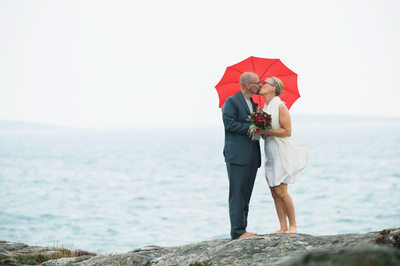 Rött paraply  kyss brudpar vid havet söder om Göteborg