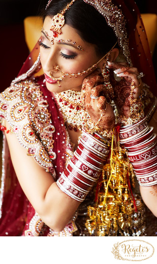 Portrait of an Indian bride sitting on stage and posing in front of camera  on haldi ceremony - SuperStock