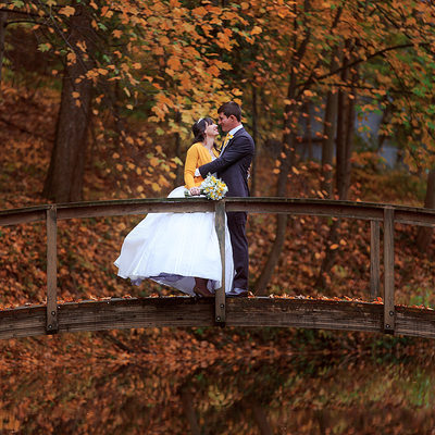 couple-embracing-bridge-fall-leaves