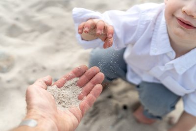 Grandson and grandad playing with sand