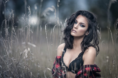 Sexy brunette wearing flannel in a field