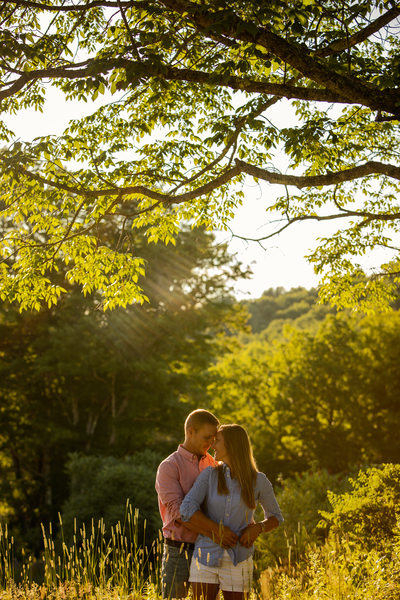 Engaged couple posing under tree