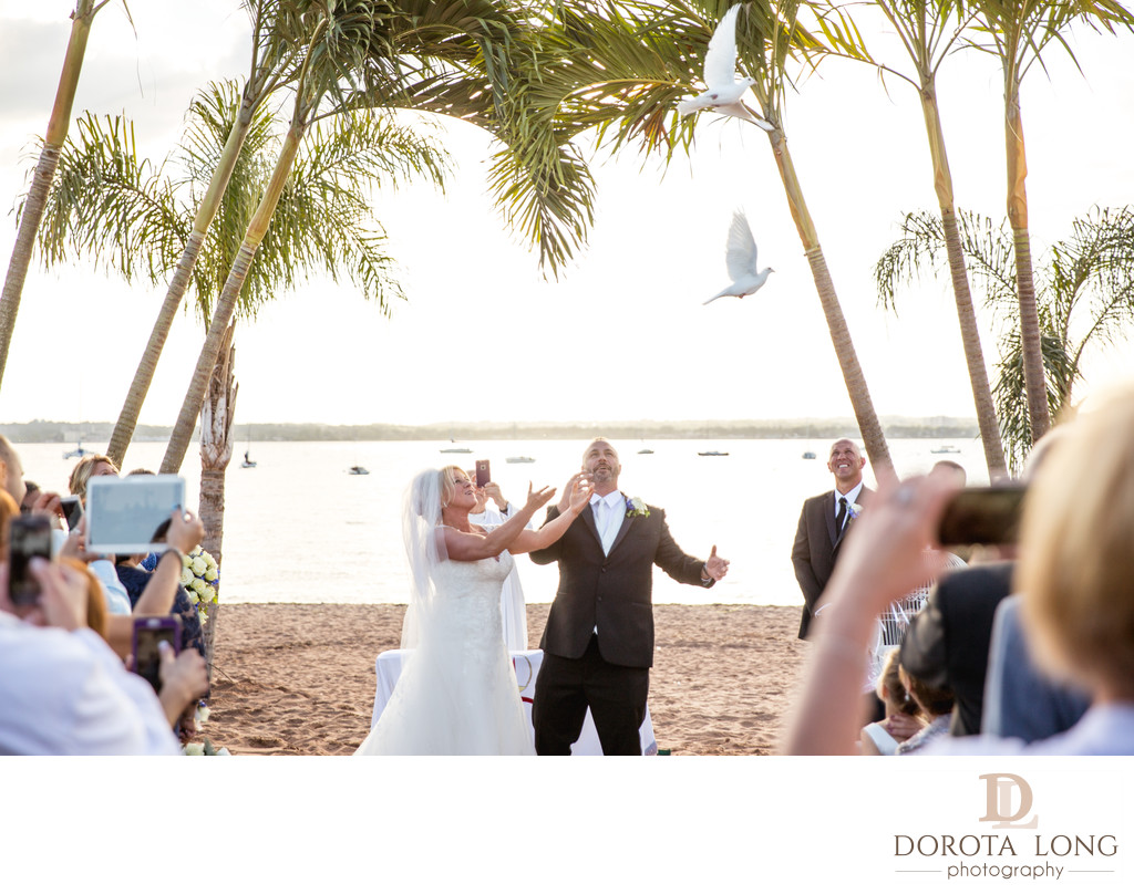 Bride and groom releasing white doves after ceremony