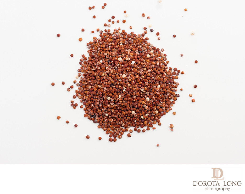 red quinoa spilled on white background