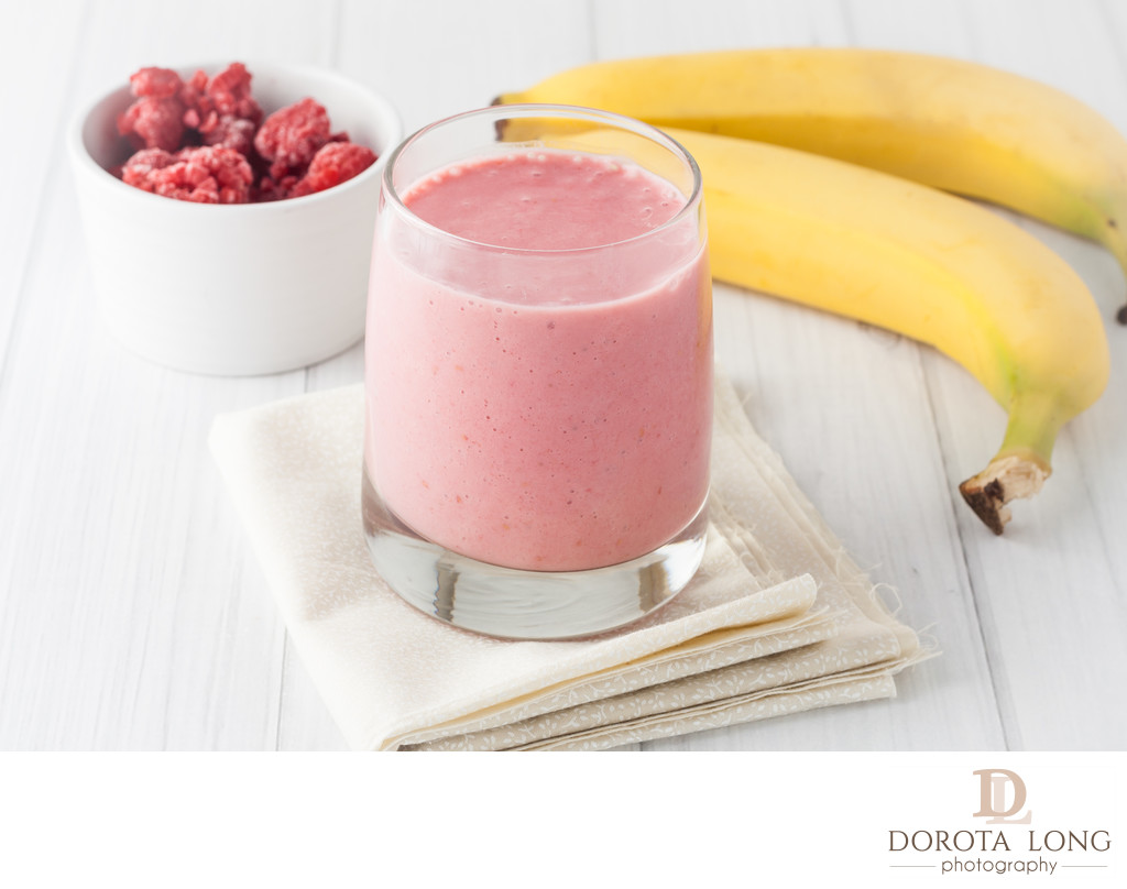 a glass of fresh homemade frozen raspberries and banana smoothie