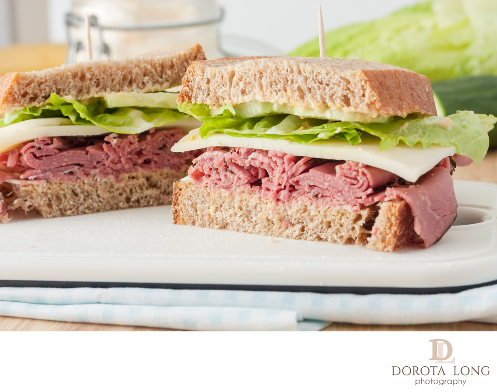 sandwich with roast beef, cheese, mustard and lettuce on whole wheat italian bread