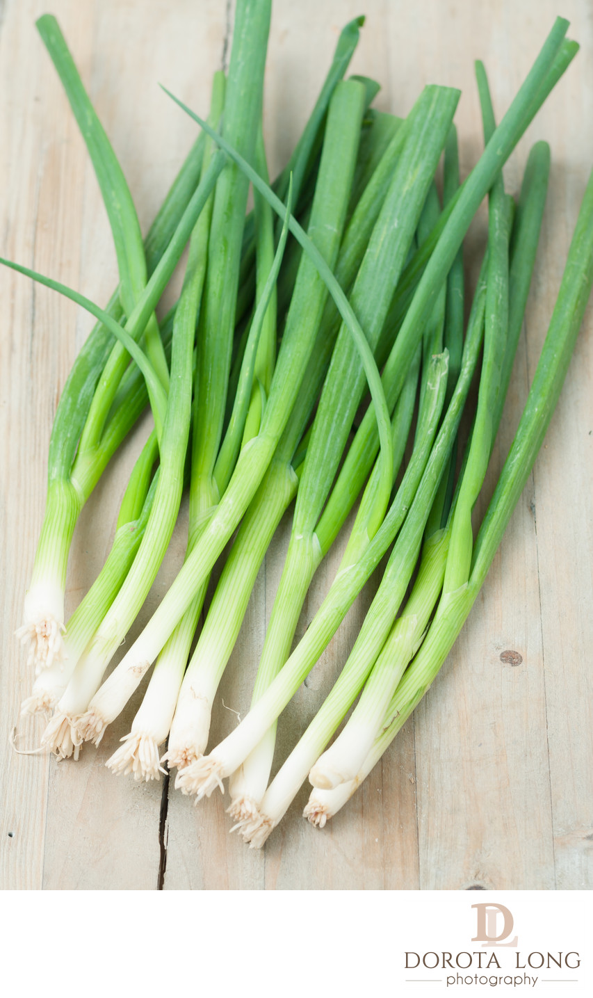 green onions isolated on wooden background