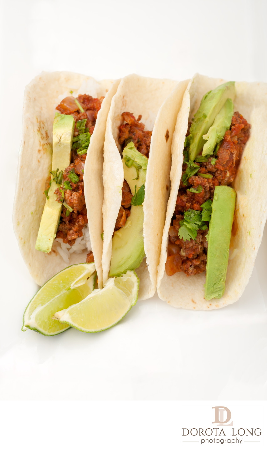 three homemade soft tacos with ground meat, avocados, cilantro and rice