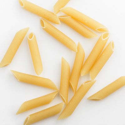 uncooked penne isolated on white background