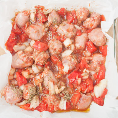 uncooked chopped sausages in baking dish
