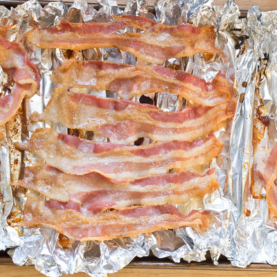 baked bacon strips on foil on cooking sheet