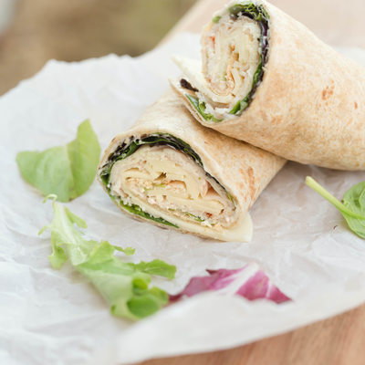 a healthy wrap with turkey, greens and cheese made with whole grain tortilla wrap