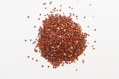 red quinoa spilled on white background