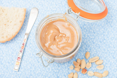 peanut butter in glass jar on blue background