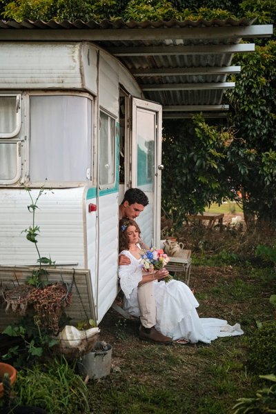 Bride and groom enjoy a moment on the steps of their caravan