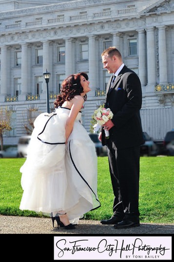 Cute Bride lifting wedding dress for Groom at SF City Hall