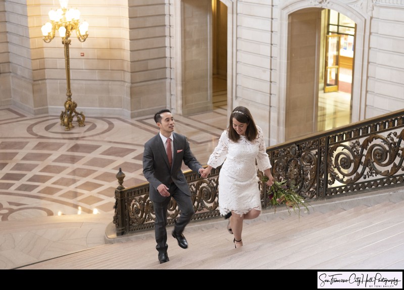 Bride and groom walking up the Grand Staircase at SF City Hall