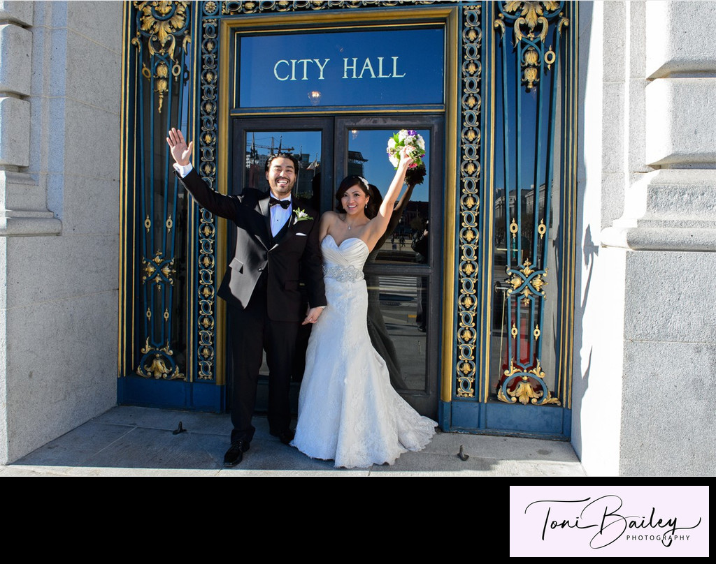 newlyweds at city hall door sign