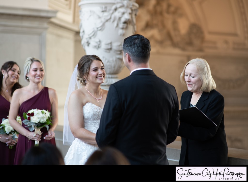 Bride sweetly smiles at groom during wedding ceremony