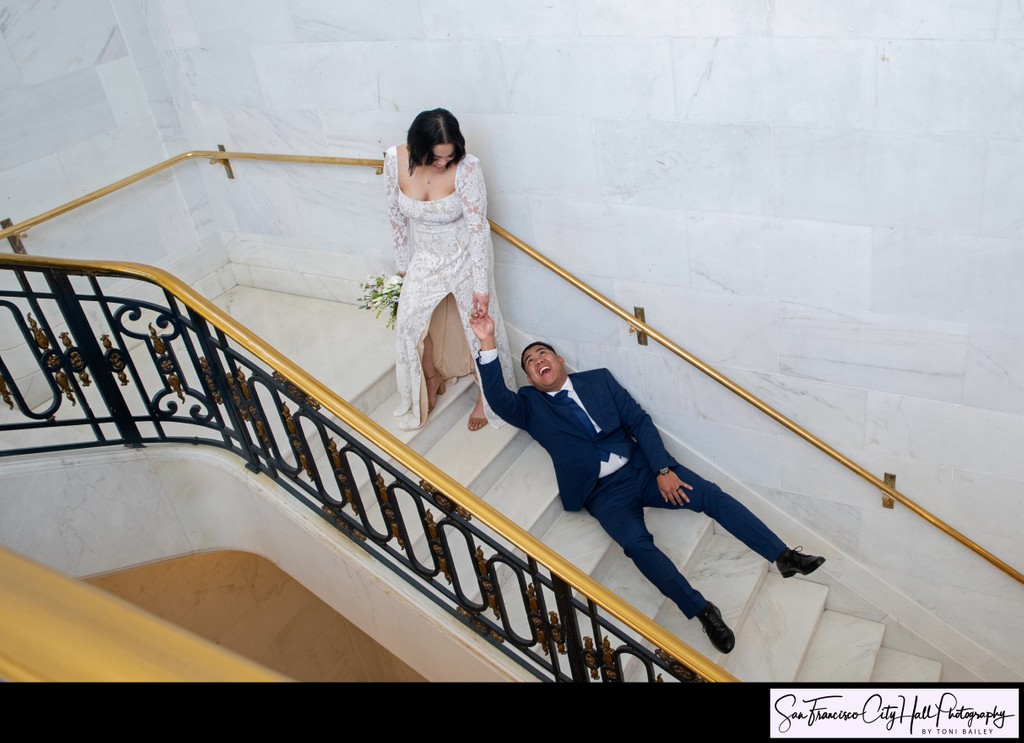 Funny wedding photography image- Bride dragging groom upstairs