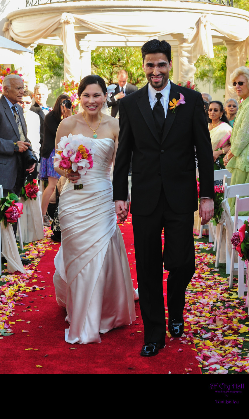 bride and groom walking down flower aisle