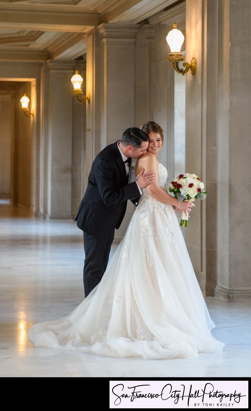 Groom kisses shoulder of his bride at San Francisco city hall - Wedding picture