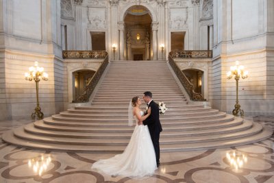 SF City Hall bride and groom showing love at the Grand Staircase