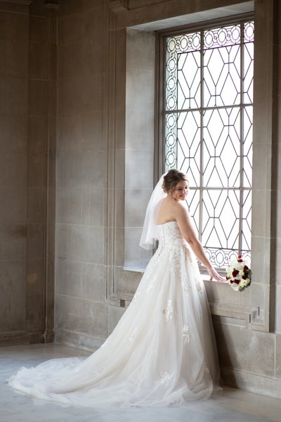 Pretty bride displays dress for San Francisco city hall wedding photographers