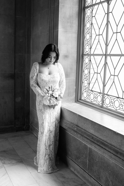 Black and White wedding photography of bride looking at Bouquet